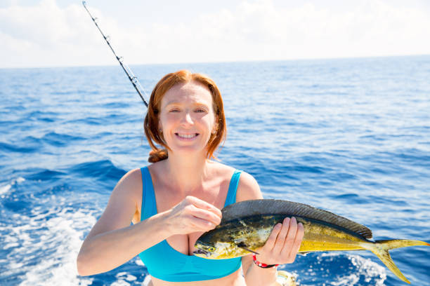 ドラドマヒマヒ魚幸せなキャッチを釣る女性 - fisherwoman ストックフォトと画像