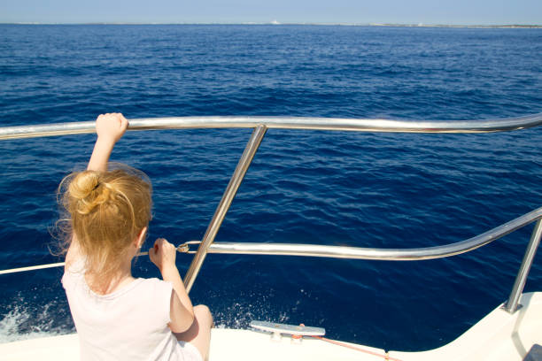 istock Blond little girl rear view sailing in boat 1344450505
