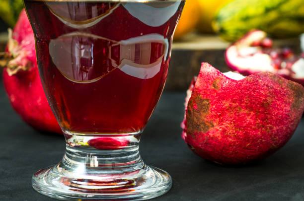 Glass with pomegranate juice on a colored background from seasonal product