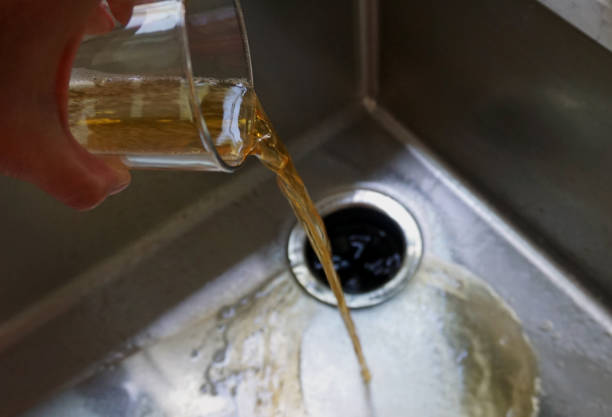 pouring beer down the drain - dry january stockfoto's en -beelden