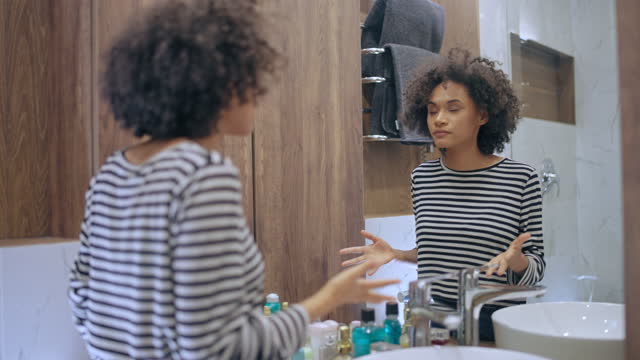Nervous woman talking to mirror reflection, preparing for important conversation
