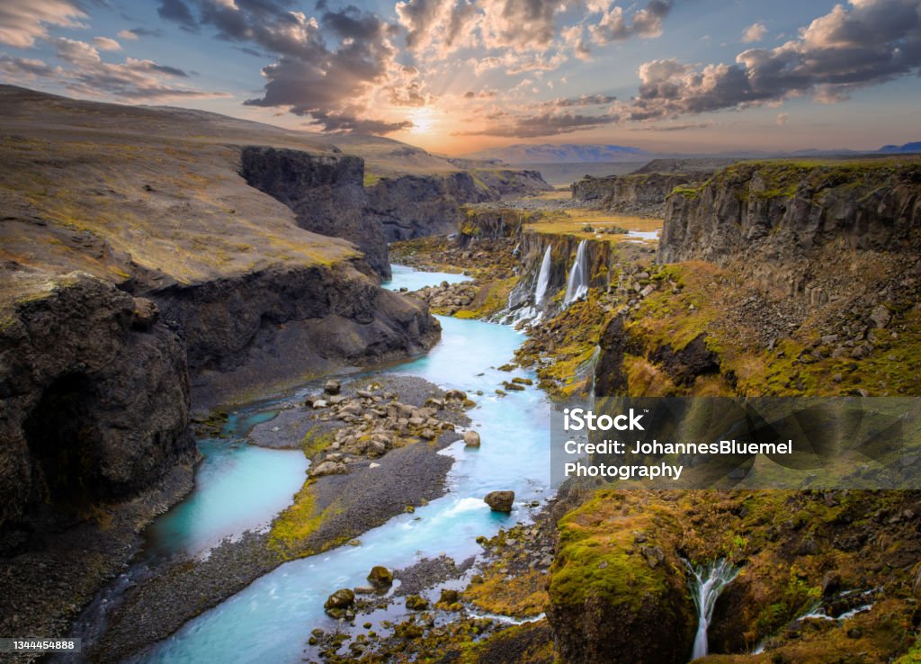 Beautiful sunset and landscape of Sigoldugljufur canyon with many small waterfalls and the blue river in Highlands of Iceland Scenic landscape view of incredible Sigoldugljufur canyon in highlands with turquoise river and sunset, Iceland. Volcanic landscape on background. Popular tourist attraction. Iceland Stock Photo