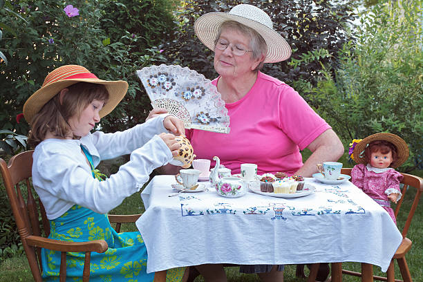 hermosa niña y su abuela tener una fiesta de té - tea party little girls teapot child fotografías e imágenes de stock
