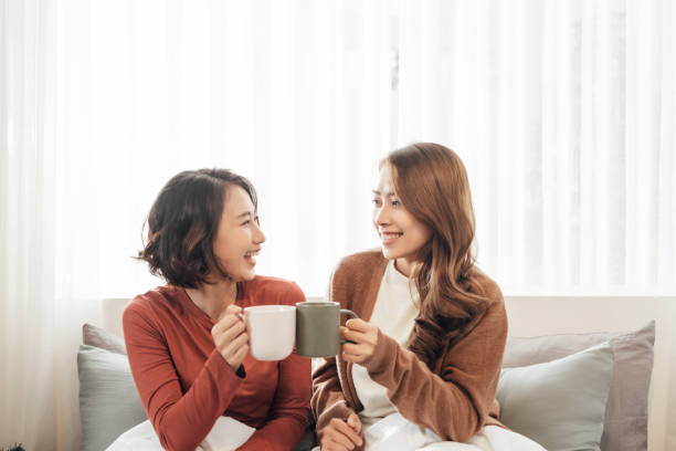 istock girlfriends friends drink tea on the couch 1344457220