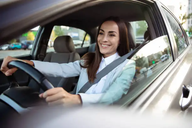 Photo of Portrait of cute female driver steering car with safety belt