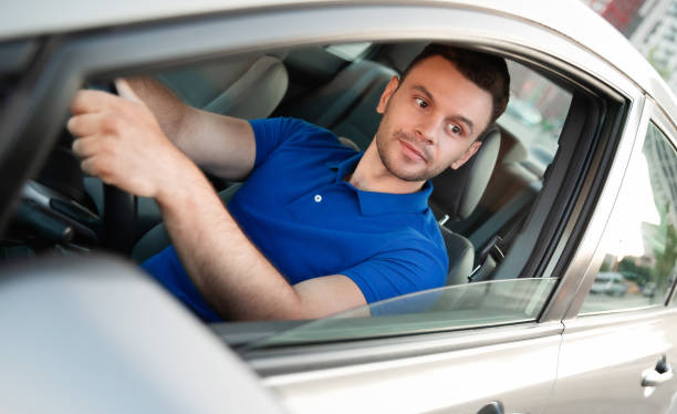 istock Confident young handsome successful man is driving his modern car 1344459503