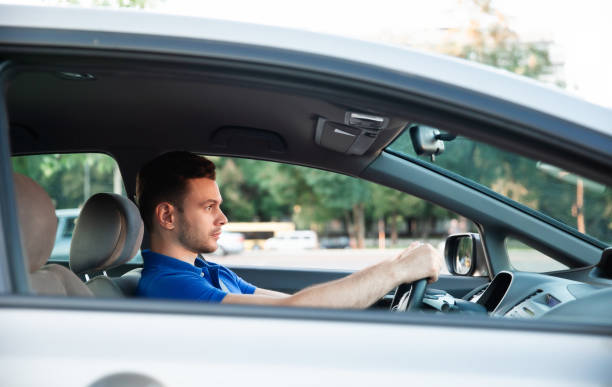istock Confident young handsome successful man is driving his modern car 1344459617
