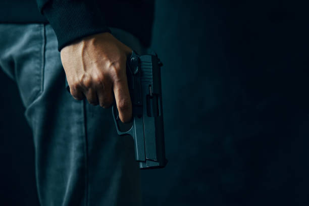 istock Criminal with revolver on dark background. 1344461653