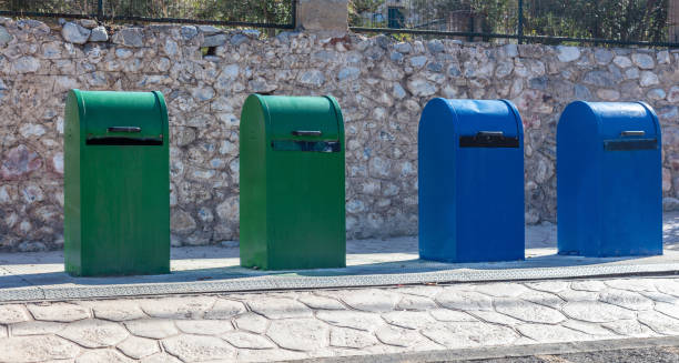 istock Garbage Trash Bins. Green and blue color dustbins in a row on a sidewalk. Recycling, environment 1344462471