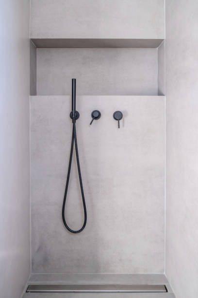 Modern bathroom interior with hand shower faucets black color, on grey ceramic tile wall background
