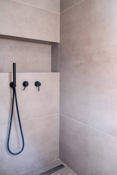 istock Modern bathroom interior with hand shower faucets black color, on grey ceramic tile wall background 1344462513