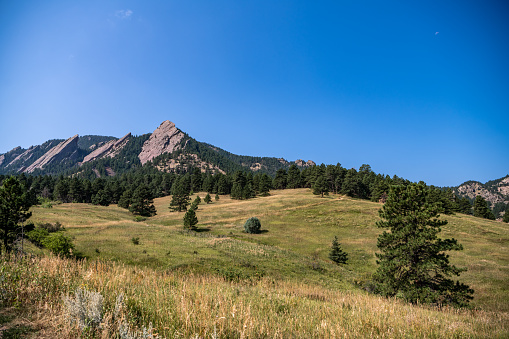Top of the mountain in focus. Beautiful scenery at the Chautauqua Park Hiking area. The famous flatirons rock formation is visible.