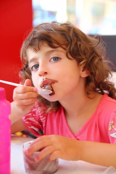 istock Girl eating chocolate ice cream dirty face 1344476521