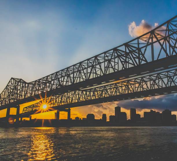 Crescent city connection A sunset view of the crecent city connection in New Orleans/ Algiers shot from the western bank of the Mississippi towards the east. With New Orleans skyline in the background algiers stock pictures, royalty-free photos & images
