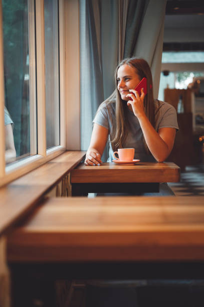 istock Small business owner talking on the phone while having coffee at her shop 1344479964