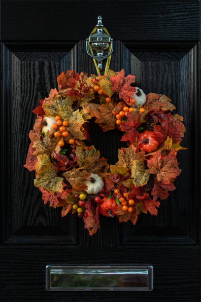 istock Thanksgiving wreath for front door. Closeup fall harvest wreath with pumpkins, maple leaf and berry for Halloween. Outdoor home decor 1344480021