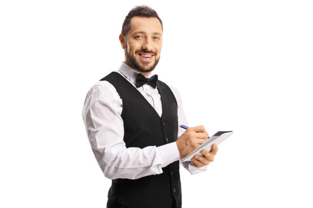 istock Waiter with a bow tie writing on a paper and smiling 1344480778