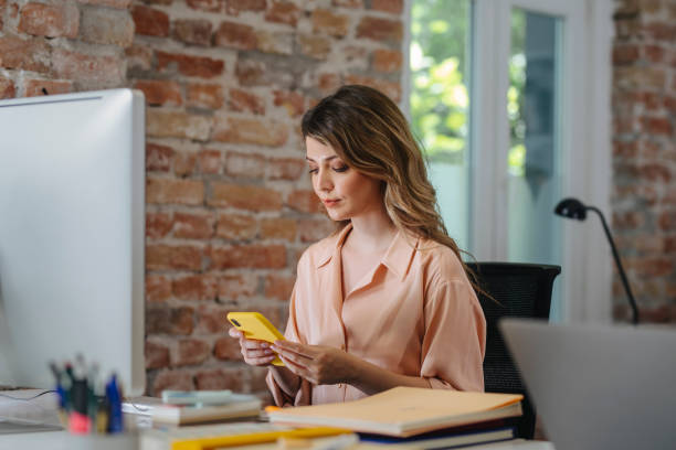 istock Smiling Business Woman Using Mobile Phone in the Office 1344481497