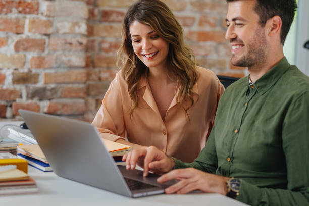 istock Happy Business People Using a Laptop Computer Together in the Office 1344481503