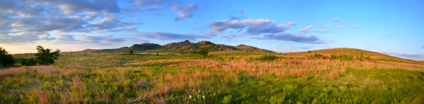 Sunset over the Wichitas - Panoramic Panoramic scene of the sunset on the Wichita Mountains in the Wichita Mountain Wildlife Refuge near Medicine Park, Oklahoma. The view from our rental property of the grass meadows was a perfect backdrop oklahoma stock pictures, royalty-free photos & images