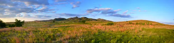 Panoramic scene of the sunset on the Wichita Mountains in the Wichita Mountain Wildlife Refuge near Medicine Park, Oklahoma. The view from our rental property of the grass meadows was a perfect backdrop