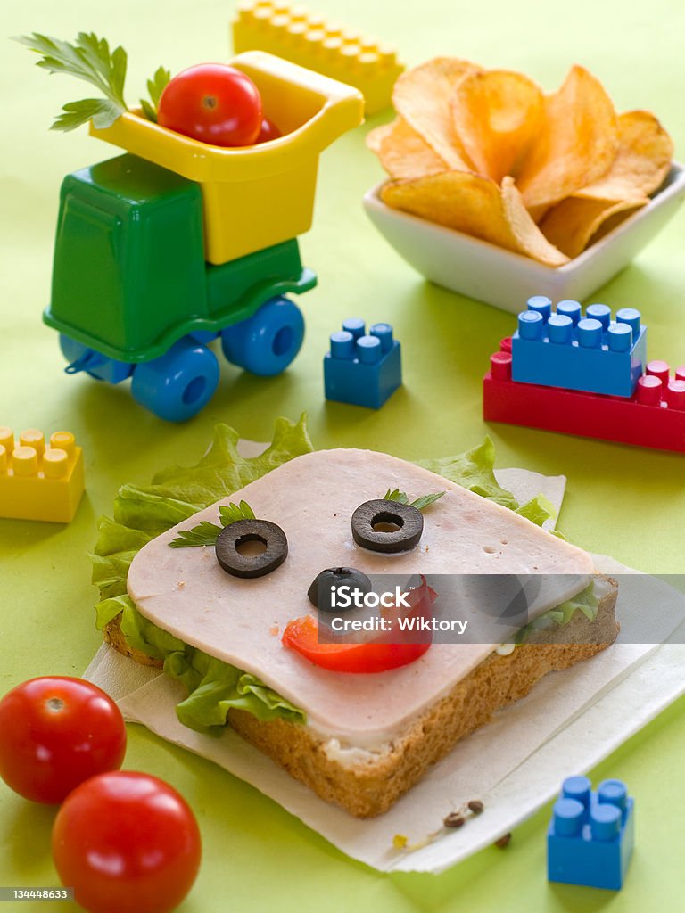 Breakfast for child breakfast with ham and lettuce for child with toys on background Blue Stock Photo