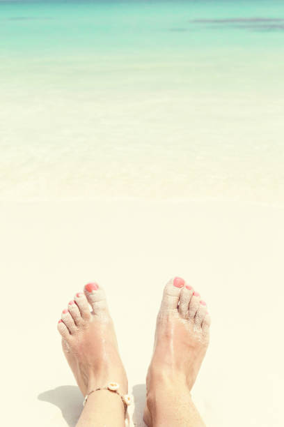 istock Woman legs on beach in sea wave 1344486376