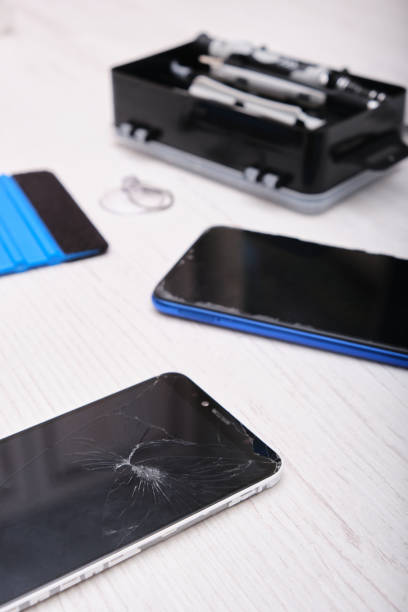 istock several phones with a broken screen, phone repair concept, a set for changing the touchscreen on a wooden table 1344496785