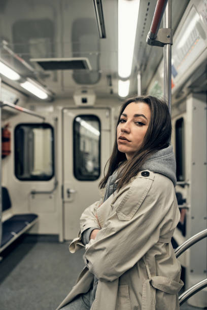 a girl in a beige trench coat rides in a subway car - 16637 imagens e fotografias de stock