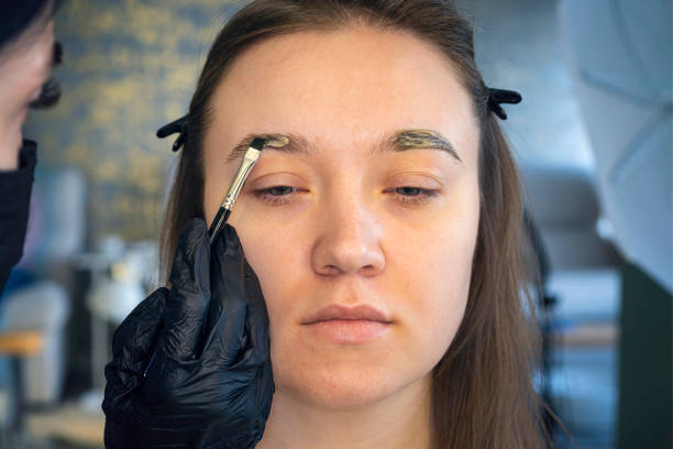 istock Eyebrow coloring is a cosmetic procedure. Young woman undergoing eyebrow correction procedure in beauty salon, closeup 1344499923