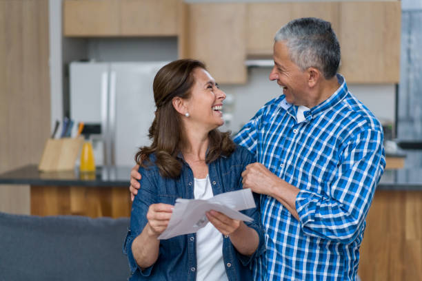 very happy couple at home opening a letter in the mail - looking into mailbox imagens e fotografias de stock