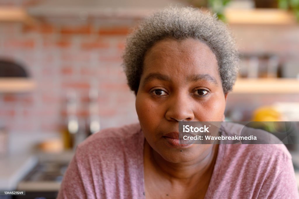 Portrait of serious african american senior woman it kitchen Portrait of serious african american senior woman it kitchen. retirement lifestyle, leisure and spending time at home. Serious Stock Photo