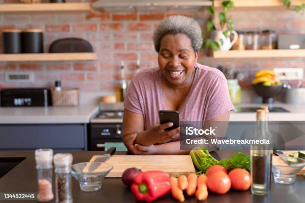 Happy African American Senior Woman Using Smartphone It Kitchen Stock Photo - Download Image Now