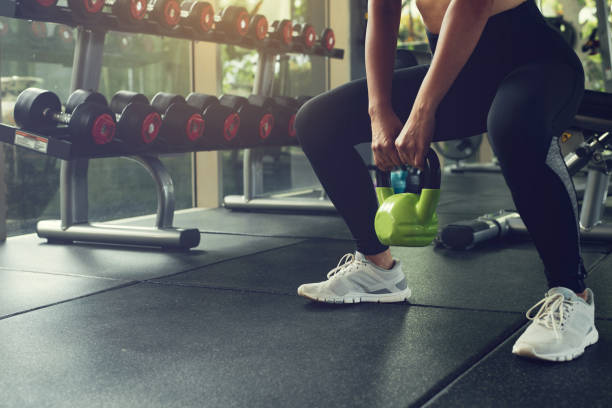istock Woman exercising with kettlebell while being in squats position at the gym. 1344523048
