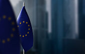 Small flags of European Union on a blurry background of the city