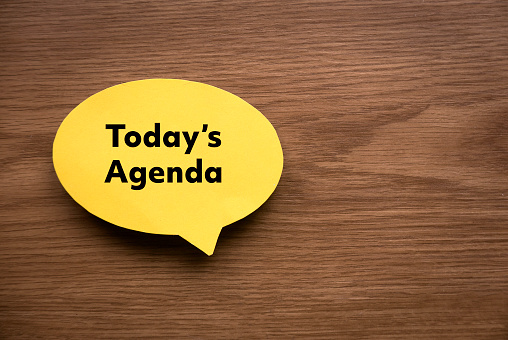 Vista superior de la burbuja de discurso amarilla escrita con la Agenda de hoy sobre fondo de madera con espacio de copia. photo