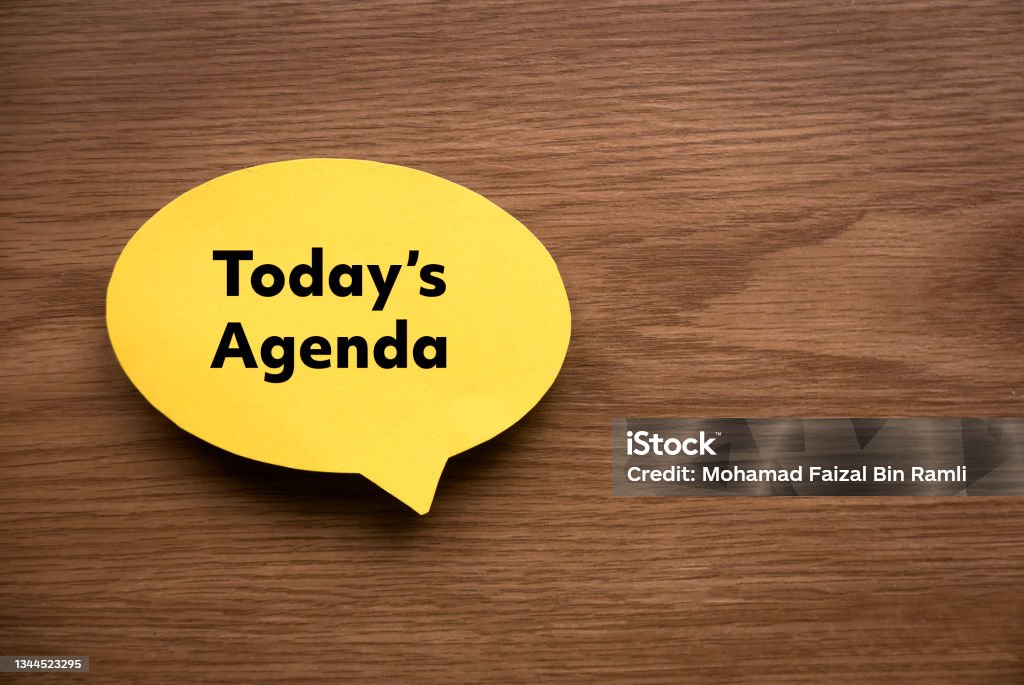 Top view of yellow speech bubble written with Today's Agenda on wooden background with copy space. Meeting Stock Photo
