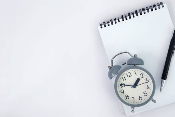 istock open spiral white notepad with pen and retro alarm clock on white background with a copy space for text , reminder for time management concept 1344527973