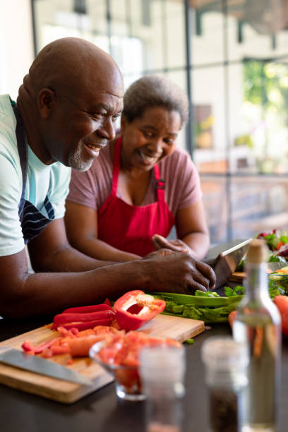 istock Happy african american senior couple cooking together in kitchen, using tablet 1344528623