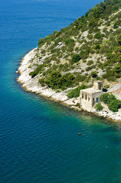 istock Rocky seashore with strange building in Croatia 134453525