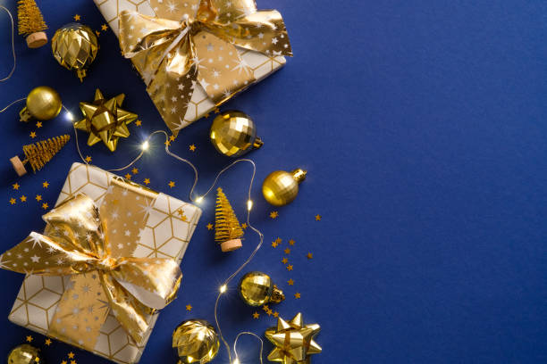 istock Golden Christmas decorations, gift boxes, balls, xmas trees on blue background. Flat lay, top view. Luxury Christmas postcard. 1344535268