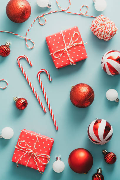 istock Flat lay red Christmas balls decoration, gift boxes, candy canes, ribbon on blue background. Vintage, retro style. 1344536456