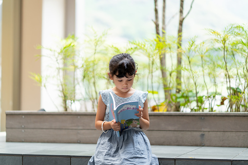 Young girl practicing to read alone. Okayama, Japan