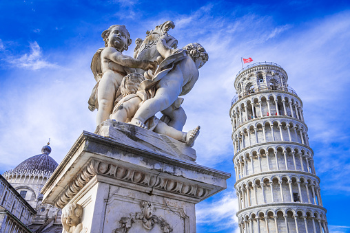 Pisa, Italy. Campo dei Miracoli with Putti Fountaind and Leaning Tower, world famous attraction in Tuscany.