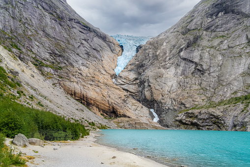 Waterfall and meltwater lake in the valley below Briksdal Glacier in Norway.