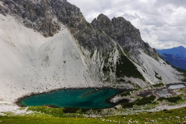 istock green mountain lake at a high steep rocky mountain 1344539336