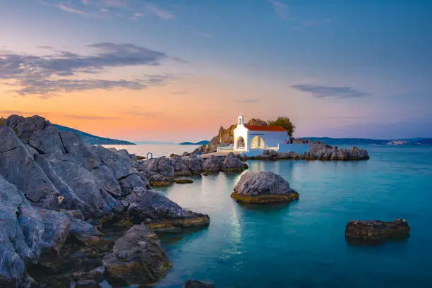 Photo of Little church of Agios Isidoros in the sea over the rocks, Chios island, Greece.