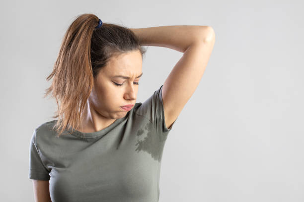 腕を上げた若い女性、脇の下の汗をかいた - sweat armpit sweat stain shirt ストックフォトと画像