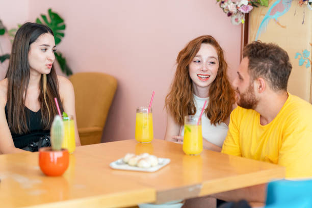 istock Grop of friends chatting and smiling while they sitting and drinking some beverage in a cafe 1344543321