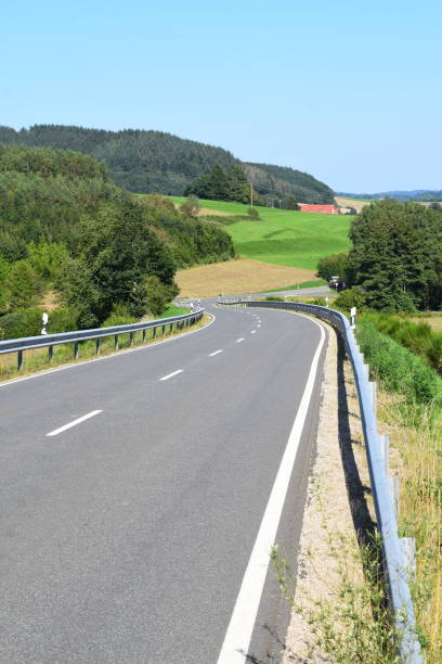 istock straight Eifel road into a valley with a hardly visible curve 1344547733